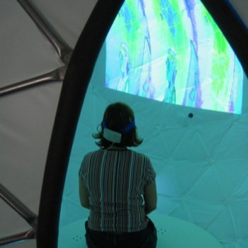 A woman sits inside the sphere